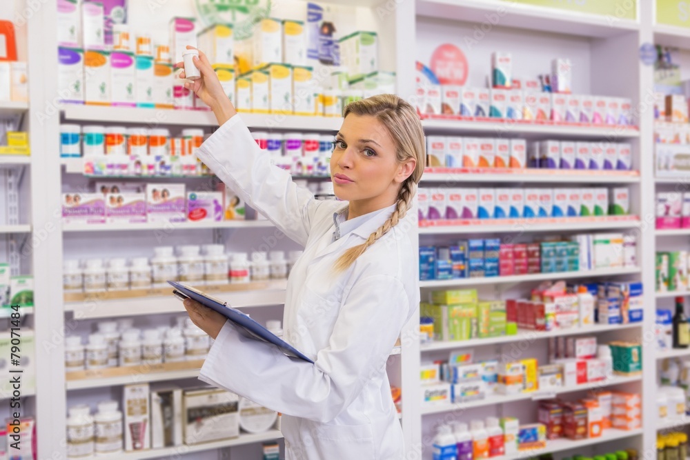 Junior pharmacist taking medicine from shelf