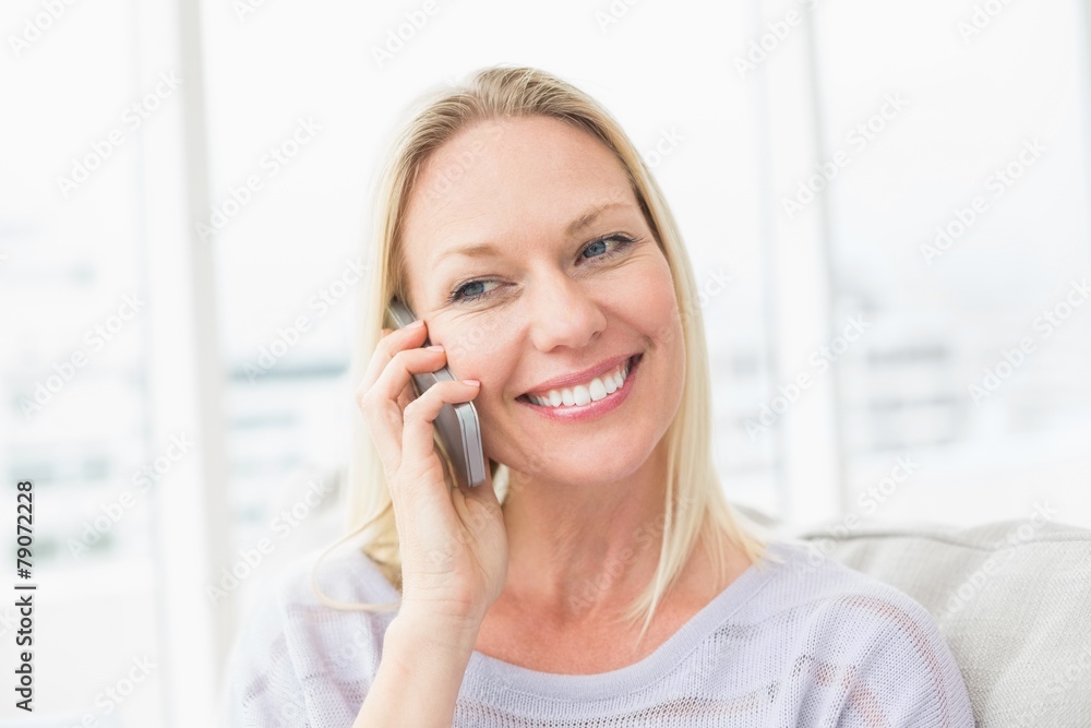 Woman talking on mobile phone in living room Woman talking on mobile phone in living room