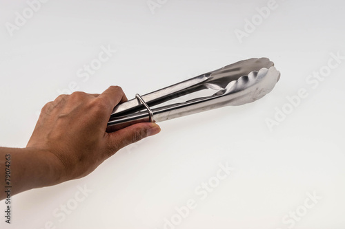 Hand holding Serving kitchen tongs isolated on a white backgroun