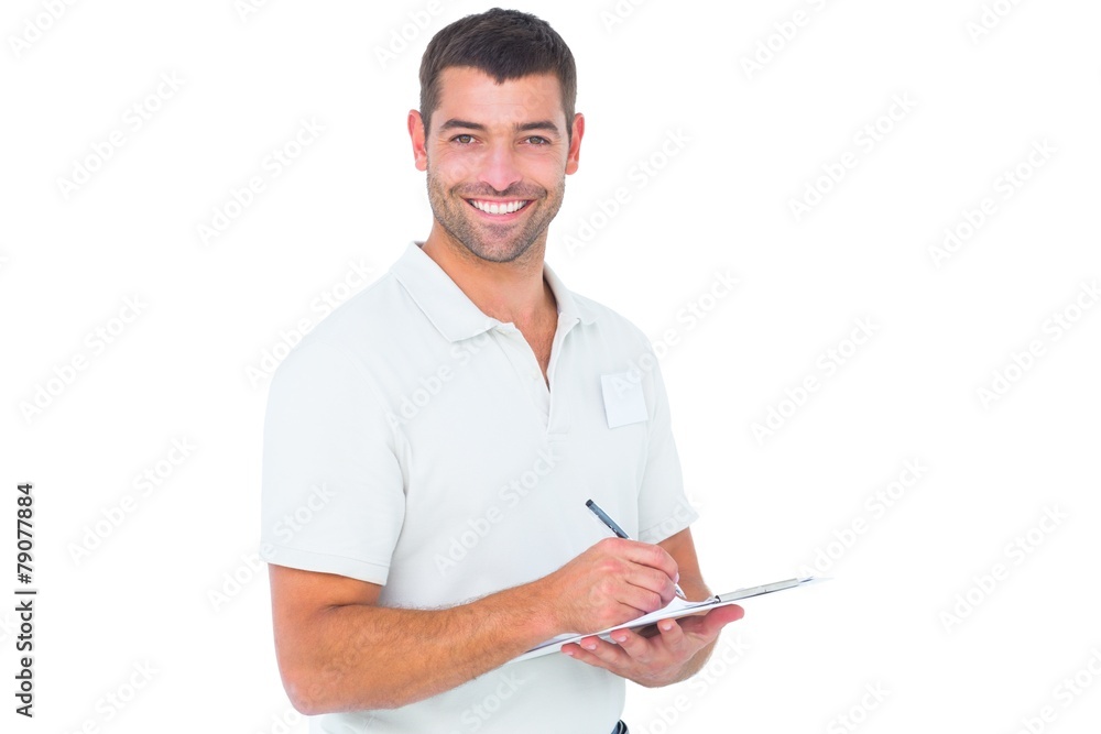 Smiling male handyman writing on clipboard Smiling male handyman writing on clipboard