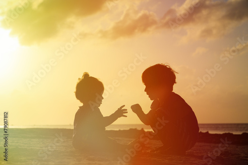 little boy and toddler girl playing at sunset