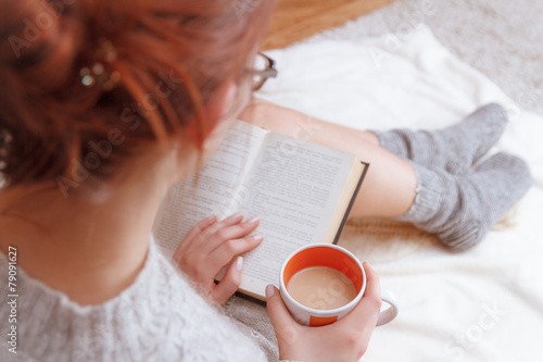 Soft photo of woman on the bed with old book  in hands