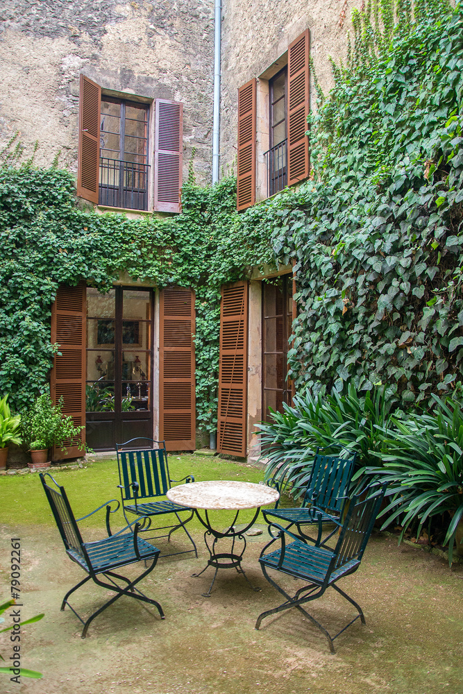 Obraz premium Courtyard cafe with trees and dense foliage.