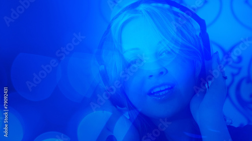 Young woman listening music blue light background