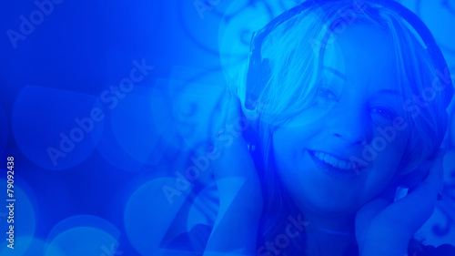 Young woman listening to the music, abstract lights background