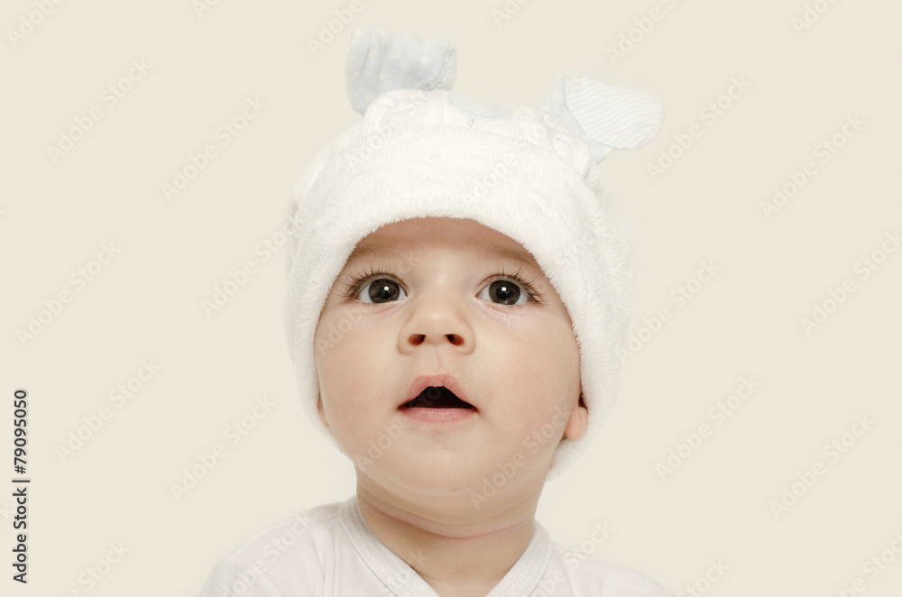Innocent baby wearing a white bunny hat looking adorable. Innocent baby wearing a white bunny hat looking adorable.