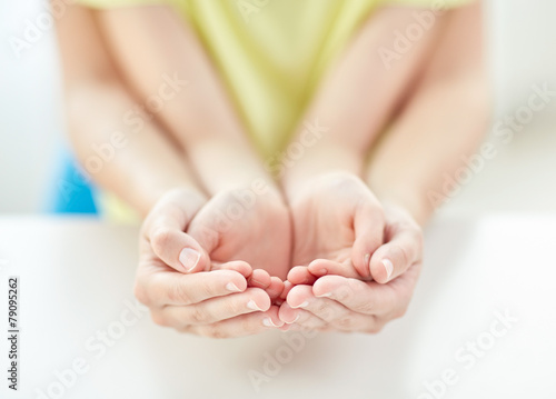 close up of woman and girl with cupped hands © Syda Productions