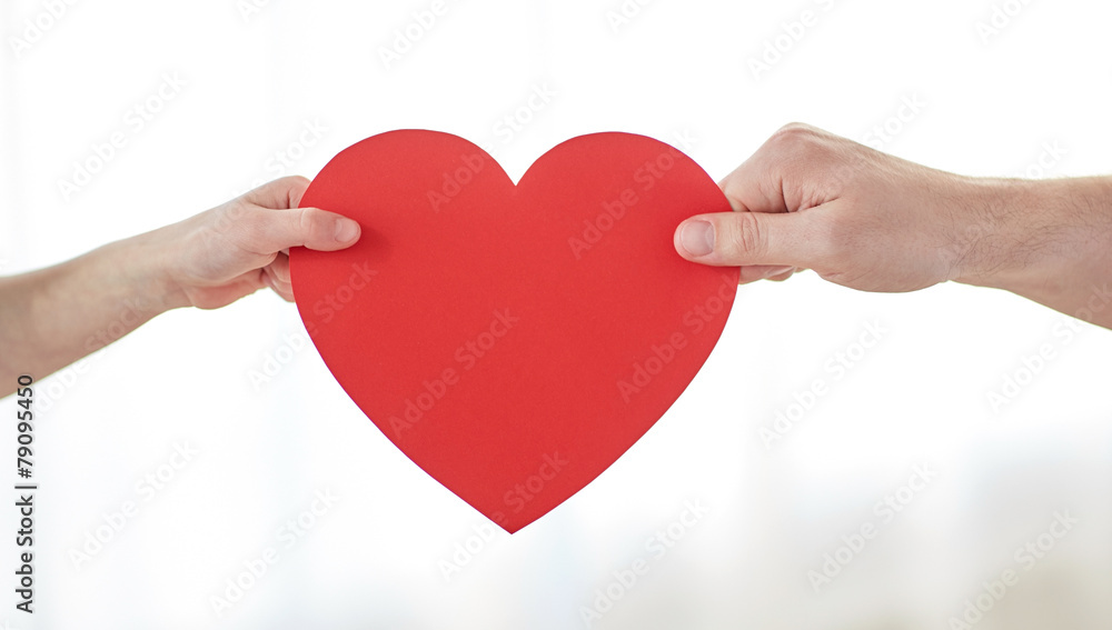 close up of child and male hands holding red heart close up of child and male hands holding red heart