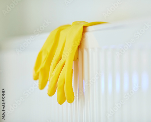 close up of rubber gloves hanging on heater