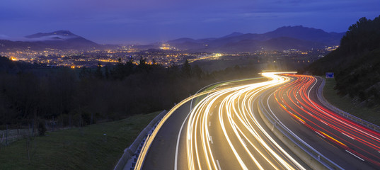 Papier peint photo Autoroute de nuit Phares nocturnes route vers la ville  © poliki
