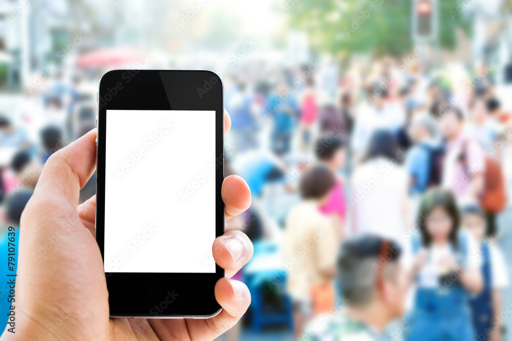 Close up hand holding smart phone against people background Close up hand holding smart phone against people background