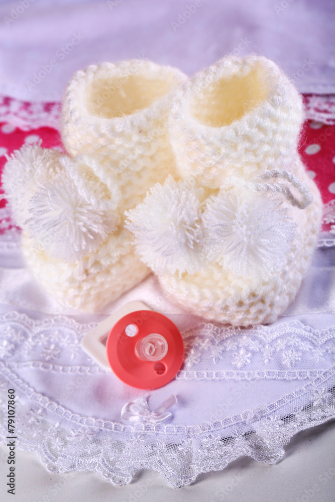 White baby boots on cloth close-up White baby boots on cloth close-up