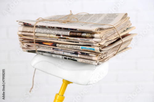 Vintage yellow bicycle with newspaper, on white wall background