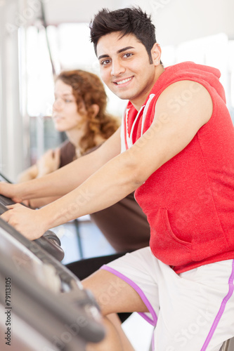 Young adult man looking at the camera while doing workout on the