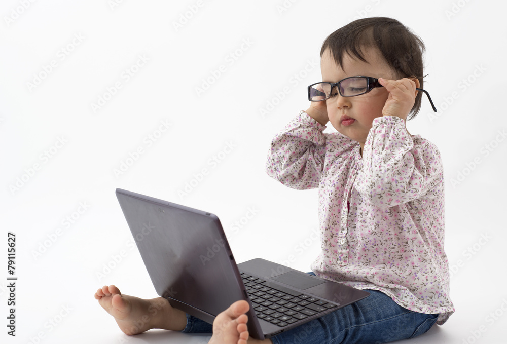 Little girl with glasses watching on the notebook Little girl with glasses watching on the notebook