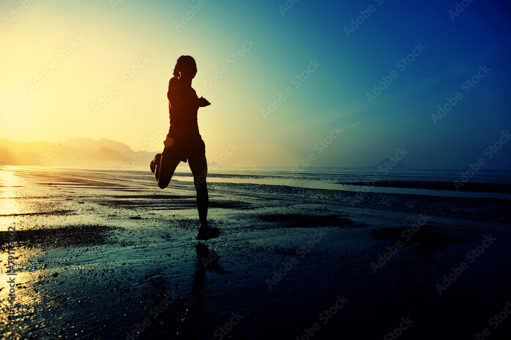 young woman running on sunrise beach  
