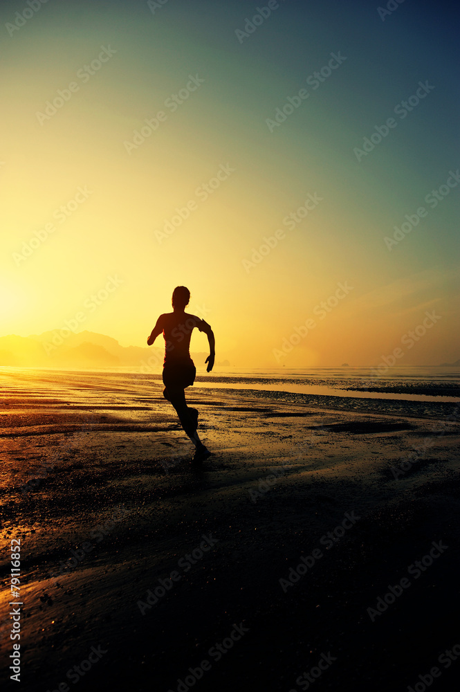 young woman running on sunrise beach 