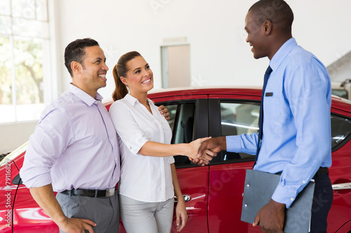 couple handshake with car salesman