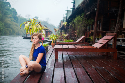 happy young woman at beach house on the River Kwai in Thailand