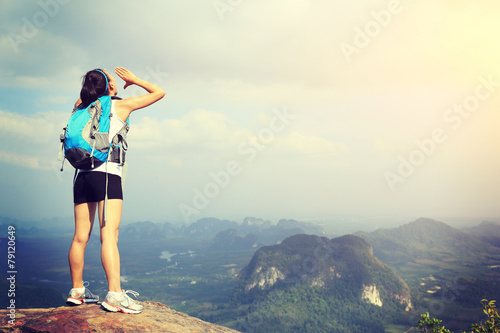 young woman hiker yelling at mountain peak