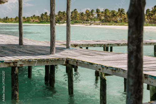 wooden deck standing in tranquil ocean against beautiful  beach