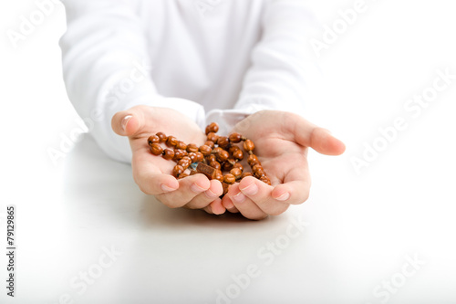 Child hands offer rosary beads