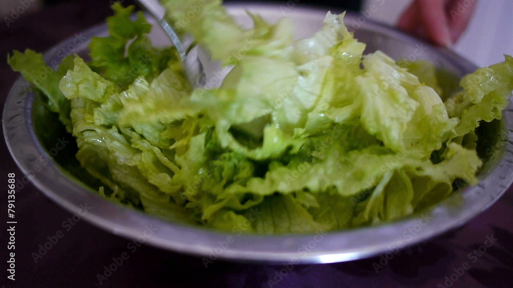 Woman preparing green salad with olive oil and vinegar dressing Woman preparing green salad with olive oil and vinegar dressing