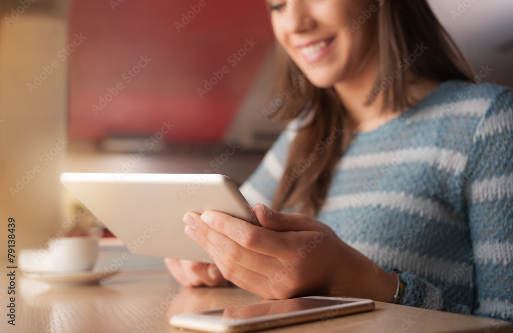 Smiling woman typing on her touch screen tablet Smiling woman typing on her touch screen tablet