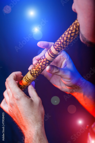 Folk musician in concert plays the melody on the Ethnic Flute photo