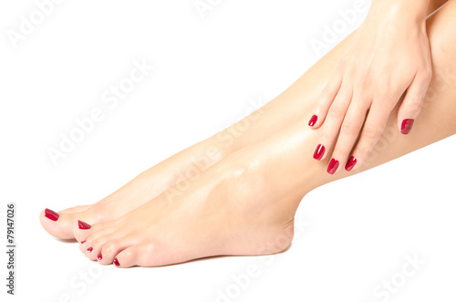 Beautiful female feet and hands with red manicure