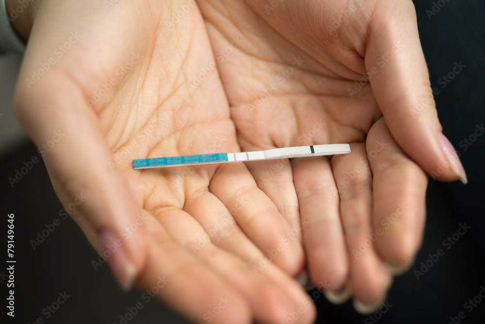 Macro shot of woman holding in hands positive pregnancy test Macro shot of woman holding in hands positive pregnancy test
