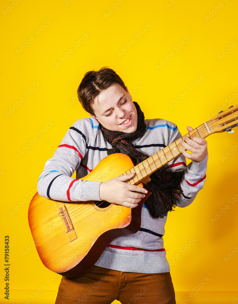 Affective teenage boy with guitar. Music concept. Affective teenage boy with guitar. Music concept.