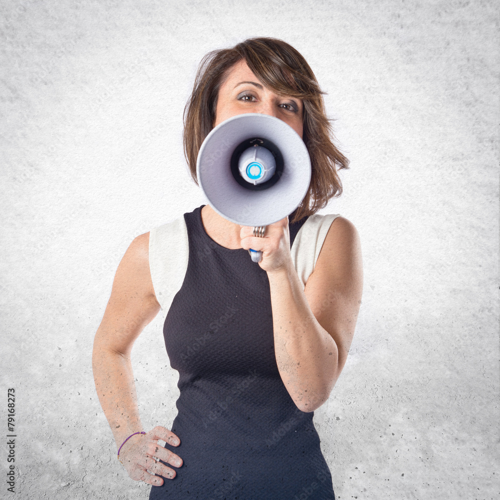 Fototapeta premium Pretty girl shouting with a megaphone over white background