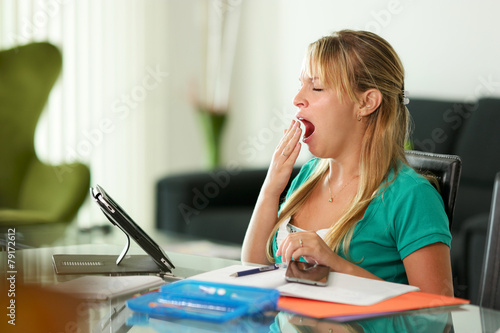 Young woman female student yawning while studying
