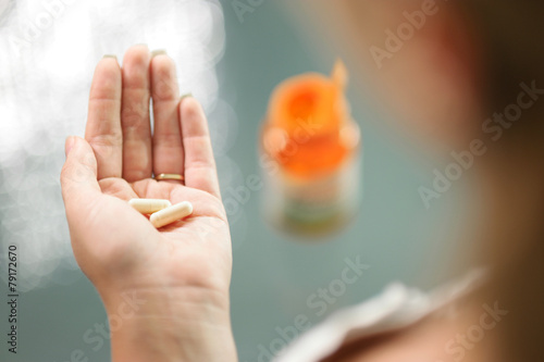 Young woman taking vitamins ginseng calcium pill