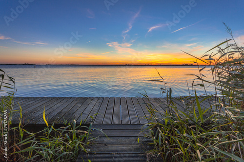 Blue and Orange Sunset over Boardwalk on the shore of a Lake