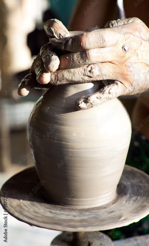 hands of a potter manufactures clay pot