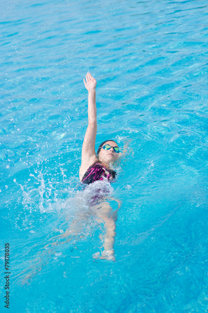 Woman in goggles swimming back crawl style