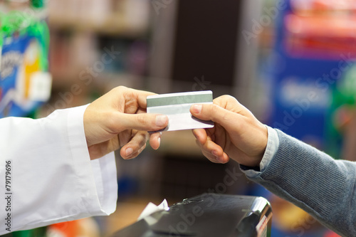 Hand of customer giving credit card at checkout