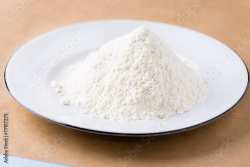 Heap of wheat flour on white plate