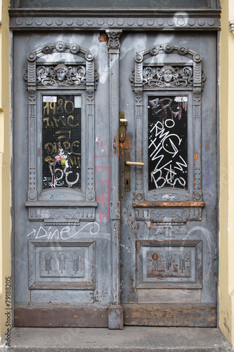 Photography Old wooden door in Prague, written in graffiti