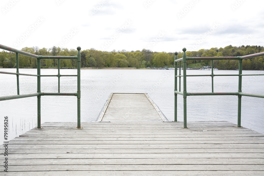 Naklejka premium Wood pier with iron railing by lake, Stockholm, Sweden.