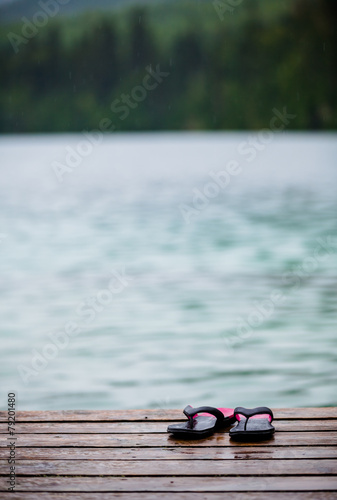 Flip flops on a Dock in front of a Turquoise Water Lake