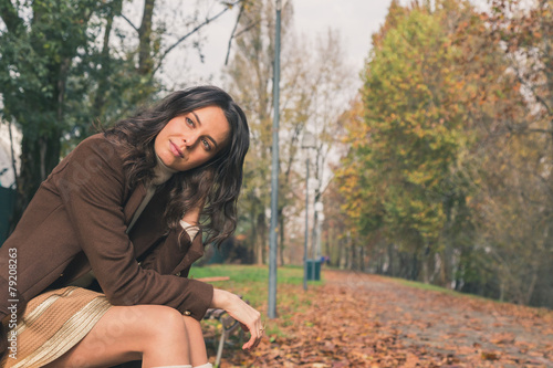 Beautiful young woman posing in a city park
