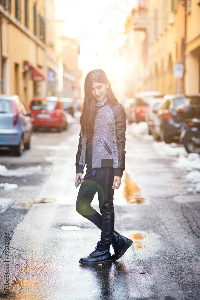 Fototapeta premium Brunette woman portrait posing in the street. Back light effect,