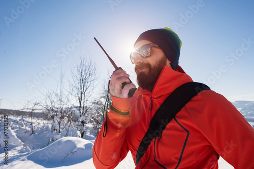 Rescue man talking with portable radio on mountain snow landscap