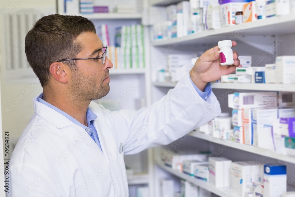 Handsome pharmacist holding medicine jar Handsome pharmacist holding medicine jar