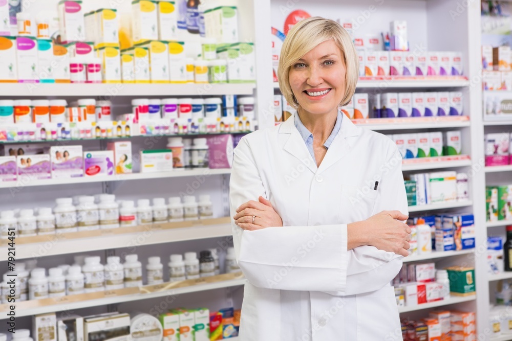Blonde pharmacist with arms crossed smiling at camera