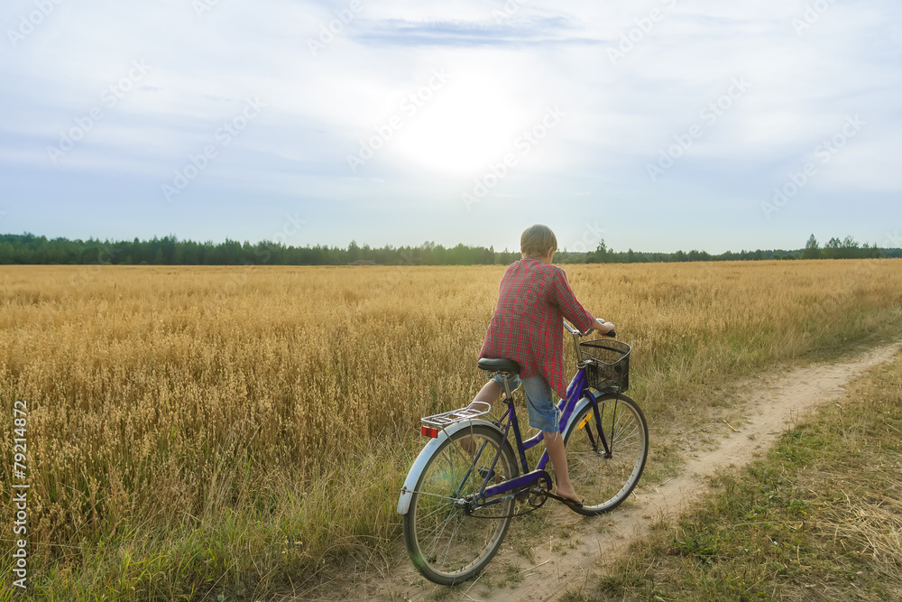 Teenager boy enjoying cycling on country road
