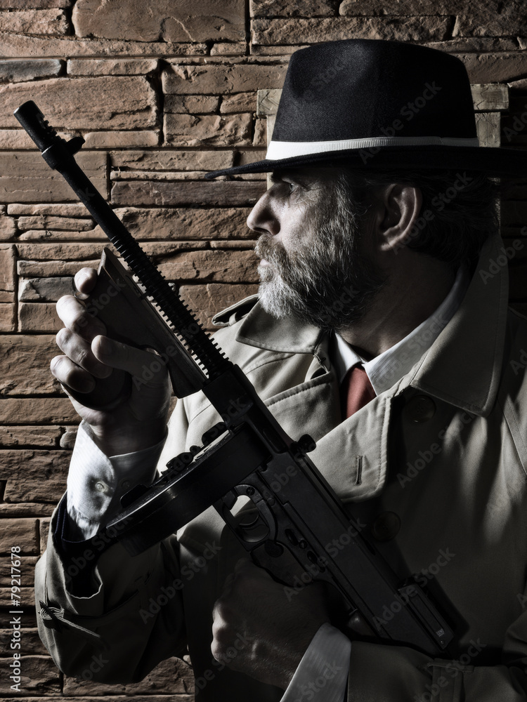 Fototapeta premium Police or Gangster, on a wall, carrying a submachine gun